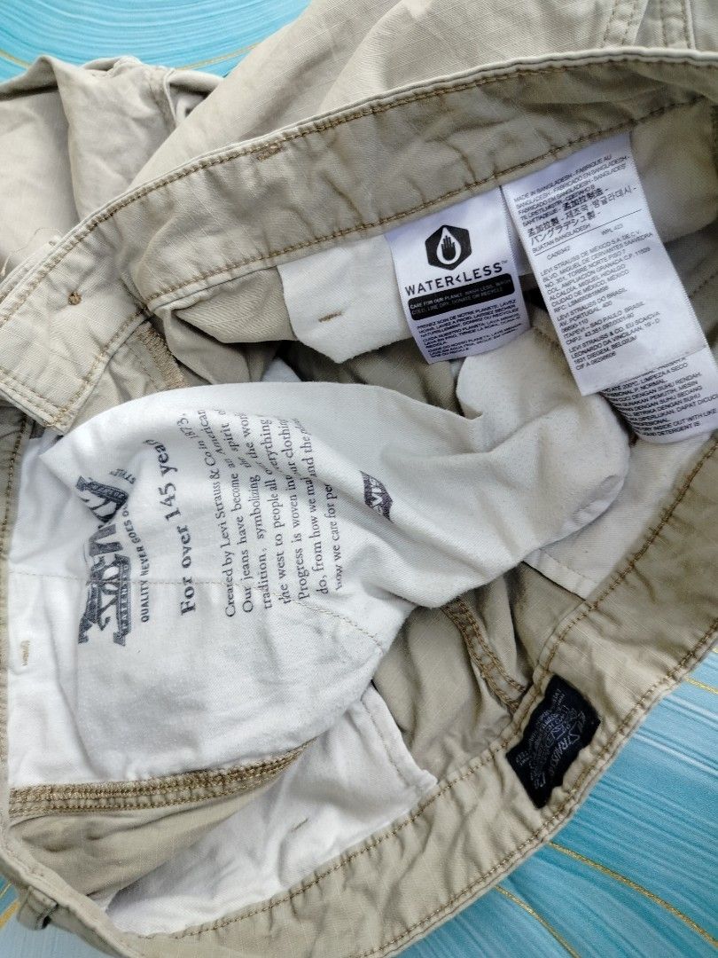 Levi's Khaki Cargo Shorts Size 36 (Category: Shorts) located in Manila. Submitted by gerald_quinto (Listing ID 1465482784, Image 2). Description: - Brand: Levi's - Color: Khaki - Size: 36 - Style: Classic utility cargo shorts - Closure: Button closure with zip fly - Pockets: Multiple functional pockets on sides and back - Waistband: Standard belt loops - Sustainability: Features Waterless manufacturing tag.