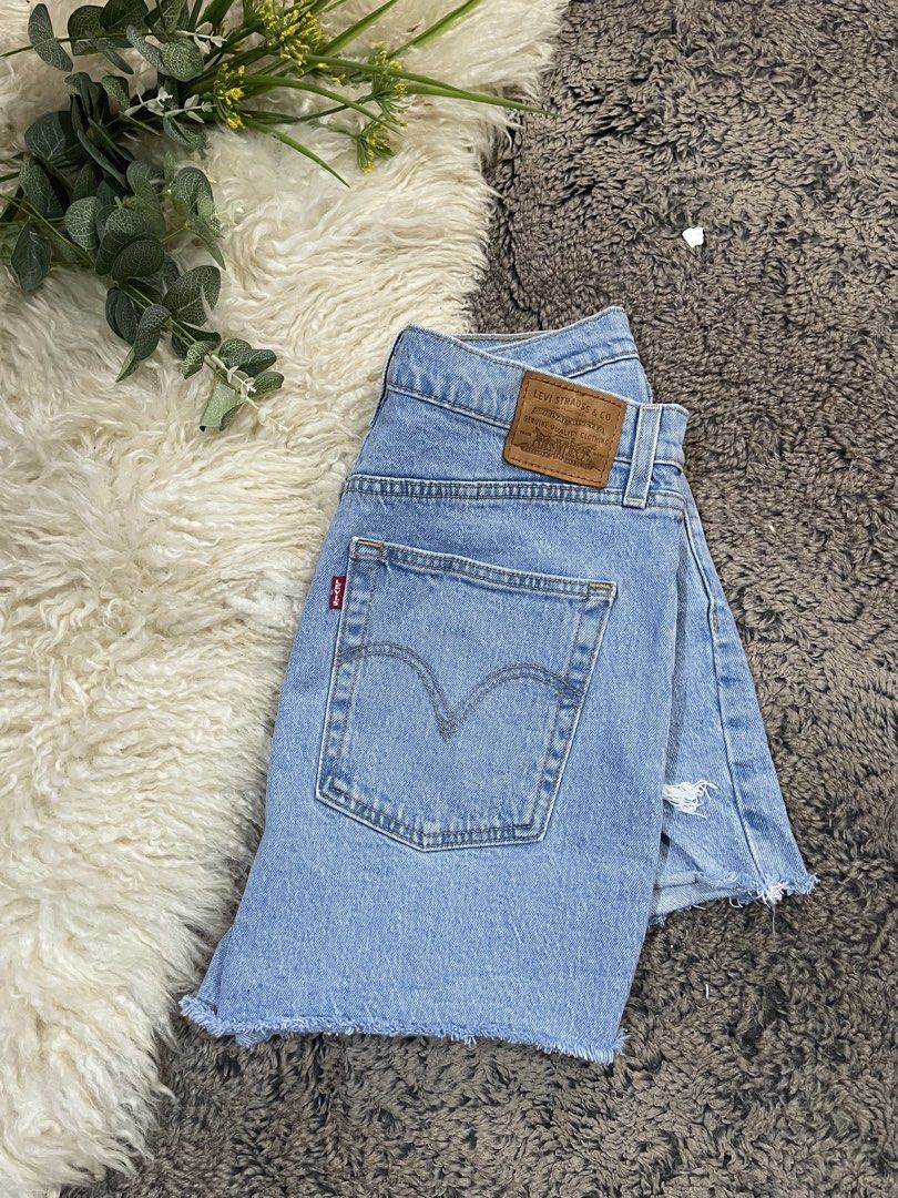 Levi's Ribcage Denim Shorts Size 32 (Category: Shorts) located in Catmon. Submitted by menchyyong97407 (Listing ID 1465404181, Image 2). Description: - Brand: Levi's - Style: Ribcage denim shorts - Color: Light blue wash - Size: 32 - Fit: High-waisted with button fly closure - Details: Distressed front pocket and leg hem, raw frayed hems, classic five-pocket styling, leather back patch, and signature red tab - Condition: Excellent/Ready to wear w