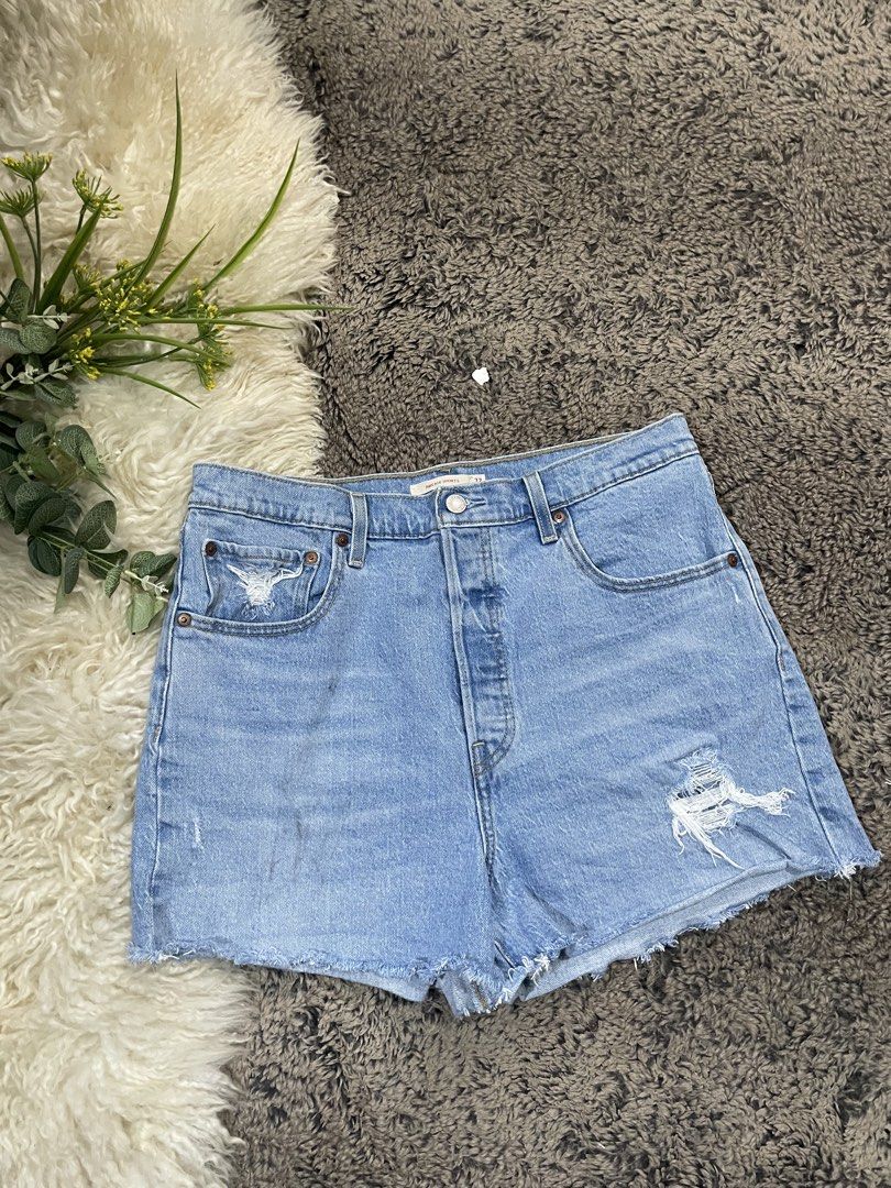 Levi's Ribcage Denim Shorts Size 32 (Category: Shorts) located in Catmon. Submitted by menchyyong97407 (Listing ID 1465404181, Image 1). Description: - Brand: Levi's - Style: Ribcage denim shorts - Color: Light blue wash - Size: 32 - Fit: High-waisted with button fly closure - Details: Distressed front pocket and leg hem, raw frayed hems, classic five-pocket styling, leather back patch, and signature red tab - Condition: Excellent/Ready to wear w
