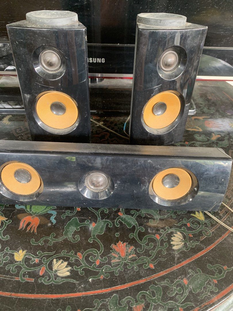 LG Speaker System S64B1-S S64H1-C (Category: Soundbars, Speakers & Amplifiers) located in Quezon City. Submitted by sojisup (Listing ID 1465489375, Image 1). Description: LG speaker set includes two tall speakers and a center bar. Model numbers S64B1-S and S64H1-C marked on labels. Impedance is 3 ohms. Black finish with textured yellow-orange speaker cones. Dusty from storage, needs a wipe down before setup..