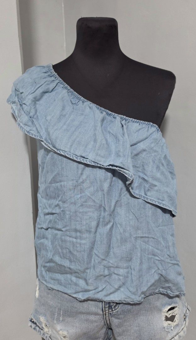 Light blue chambray one-shoulder ruffled top size S (Category: Sleeveless) located in Paranaque City. Submitted by franinnashop (Listing ID 1465441881, Image 1). Description: DECLUTTER SMALL TO MED PARANAQUE CITY - Color: Light blue denim-look (chambray) - Size: S (Made in India) - Design: One-shoulder with a wide ruffle layer front and back - Fit: Secure elastic neckline and top edge - Fabric: Soft, lightweight, and breezy - Styling: Great to pa