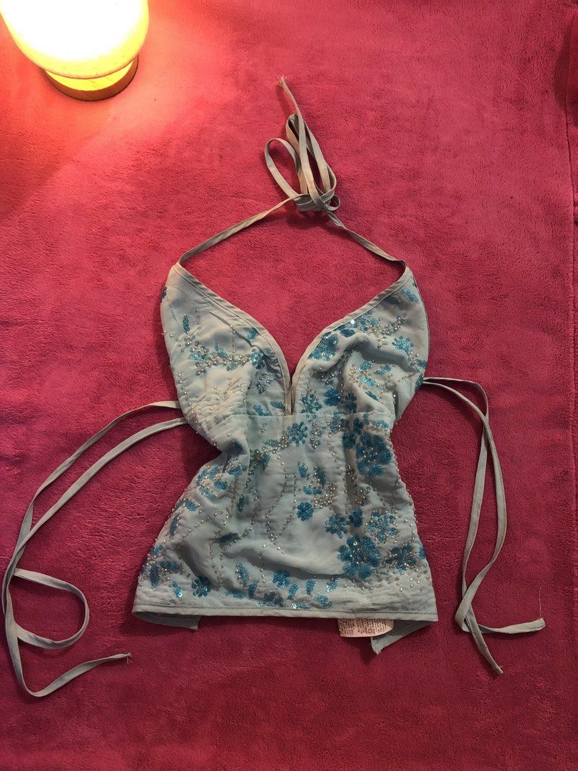 Light Blue Halter Top With Sequins And Beads (Category: Sleeveless) located in San Jose del Monte. Submitted by stla412 (Listing ID 1465542618, Image 1). Description: - Style: Y2K festival halter top - Color: Light blue with dark blue floral sequin and bead embroidery - Design: Deep V-neckline, open back, and adjustable side waist ties - Fabric: Fully lined sheer material - Condition: Brand new / Excellent.