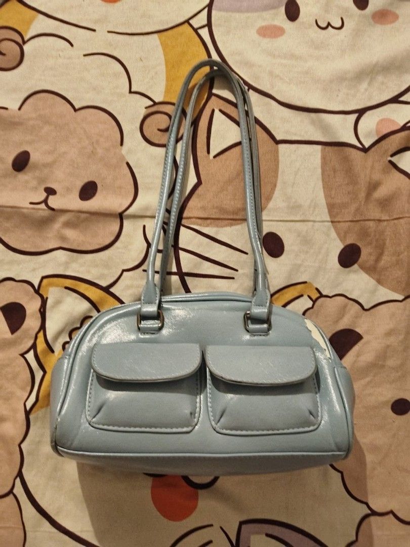 Light Blue Shoulder Bag with Double Front Pockets (Category: Shoulder Bags) located in Manila. Submitted by ksyoungieberries (Listing ID 1465514805, Image 1). Description: - Color: Light blue - Style: Shoulder bag with rounded shape and daily capacity - Features: Zipper top closure, slim double straps with silver hardware, two front flap pockets - Condition: Noticeable peeling and flaking on the right side edge near the top corner, but overall st