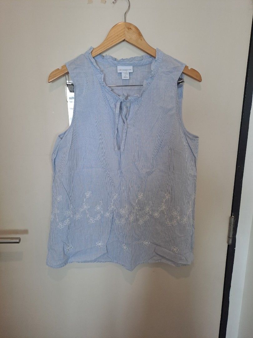 Liz Claiborne pinstripe sleevesless (Category: Blouses) located in Manila. Submitted by joanbalde39643 (Listing ID 1465442195, Image 1). Description: This is a Liz Claiborne sleeveless blue-and-white pinstripe top featuring white floral embroidery along the bottom and a ruffled keyhole neckline with tie details. 🌟.