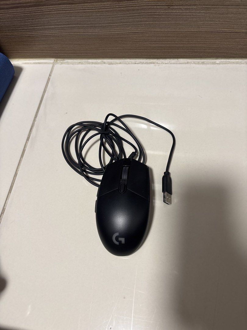 Logitech G102 Wired Mouse + FREE MOUSEPAD (Category: Mouse & Mousepads) located in Manila. Submitted by silentdeer.537e56 (Listing ID 1465424909, Image 1). Description: - Brand: Logitech G - Color: Black with smooth matte finish - Connectivity: Standard USB wired connection with a long, neatly coiled cable - Controls: Includes a smooth scroll wheel and an extra top button - Design: Ergonomic body featuring the iconic grey logo near the palm rest 