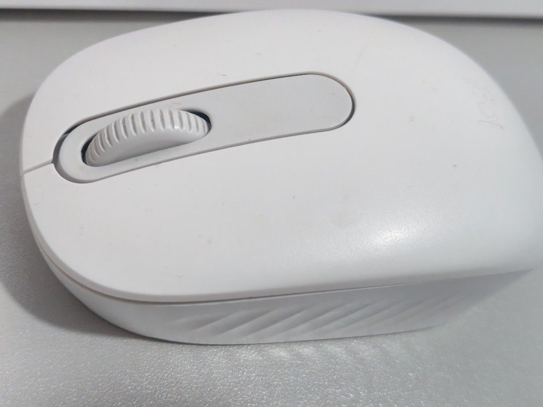 Logitech M196 White Wireless Mouse (Category: Mouse & Mousepads) located in Dasmarinas. Submitted by titaniumrosegold (Listing ID 1465394597, Image 1). Description: - Brand/Model: Logitech Wireless Mouse - Color: White with grey top panel and accents - Design: Ergonomic with textured side grips and central scroll wheel - Power: Uses standard batteries - Condition: Fully functional, minor grey wear marks on the four bottom feet - Features: Optical