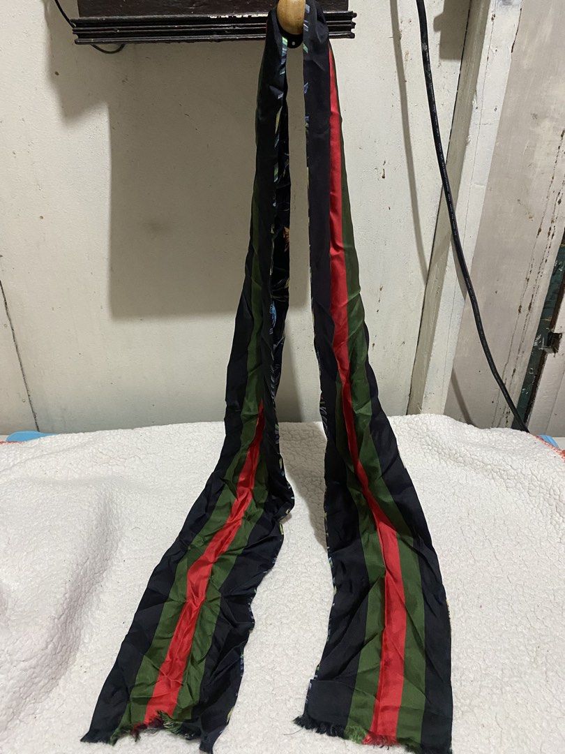 Long Black Scarf with Jungle Print and Striped Reverse (Category: Scarves) located in Manila. Submitted by resi.diaz (Listing ID 1465546210, Image 2). Description: - Approx: 78 x 6.5 inches - Style: Long reversible scarf - Design A: Vibrant jungle foliage, birds, and butterflies on black fabric - Design B: Bold red and green vertical stripes - Details: Raw frayed edges at both ends - Material: Soft silky fabric.