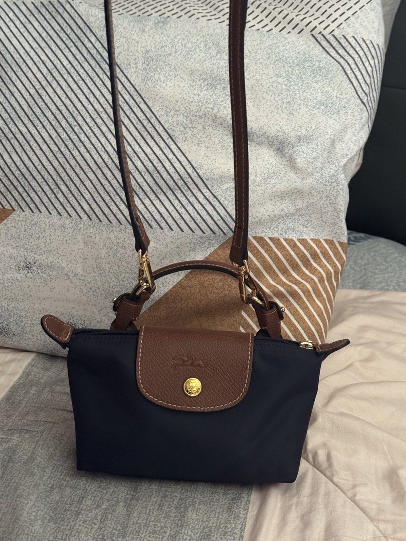 Longchamp Le Pliage Cuir Extra Small Top Handle Bag Navy (Category: Luxury Bags & Wallets) located in Manila. Submitted by iamsassycl95926 (Listing ID 1465460006, Image 3). Description: - Authentic Longchamp Le Pliage Mini Top Handle Bag - Color: Navy Blue with Brown Leather Flap and Handles - Hardware: Gold-tone - Closure: Top zipper with snap button flap - Versatility: Includes a detachable long leather strap for crossbody wear - Size: Compact 