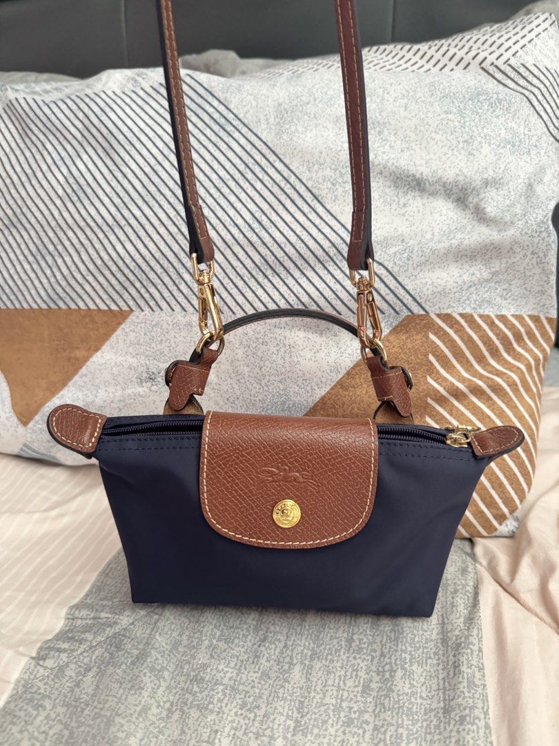 Longchamp Le Pliage Cuir Extra Small Top Handle Bag Navy (Category: Luxury Bags & Wallets) located in Manila. Submitted by iamsassycl95926 (Listing ID 1465460006, Image 2). Description: - Authentic Longchamp Le Pliage Mini Top Handle Bag - Color: Navy Blue with Brown Leather Flap and Handles - Hardware: Gold-tone - Closure: Top zipper with snap button flap - Versatility: Includes a detachable long leather strap for crossbody wear - Size: Compact 