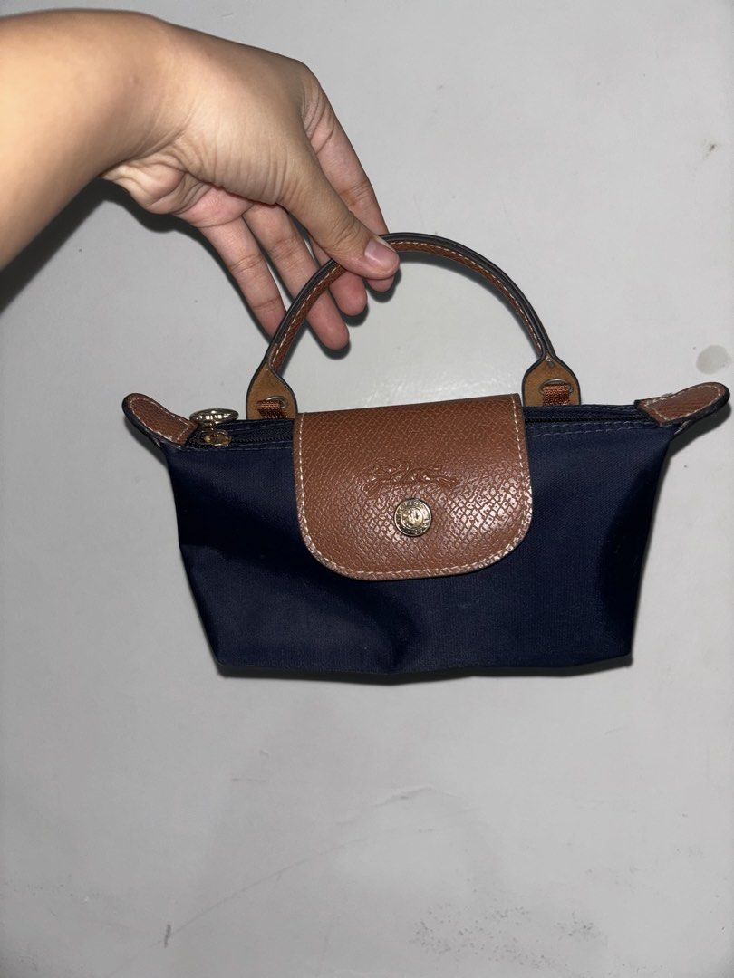 Longchamp Le Pliage Cuir Extra Small Navy (Category: Luxury Bags & Wallets) located in Dumaguete. Submitted by shopcee (Listing ID 1465516913, Image 1). Description: - Brand: Longchamp Le Pliage Mini Bag - Color: Navy blue nylon with brown leather flap and handles - Hardware: Elegant gold-tone zipper and snap button - Strap: Includes a matching detachable brown leather shoulder strap - Capacity: Compact size that easily fits your daily essentials