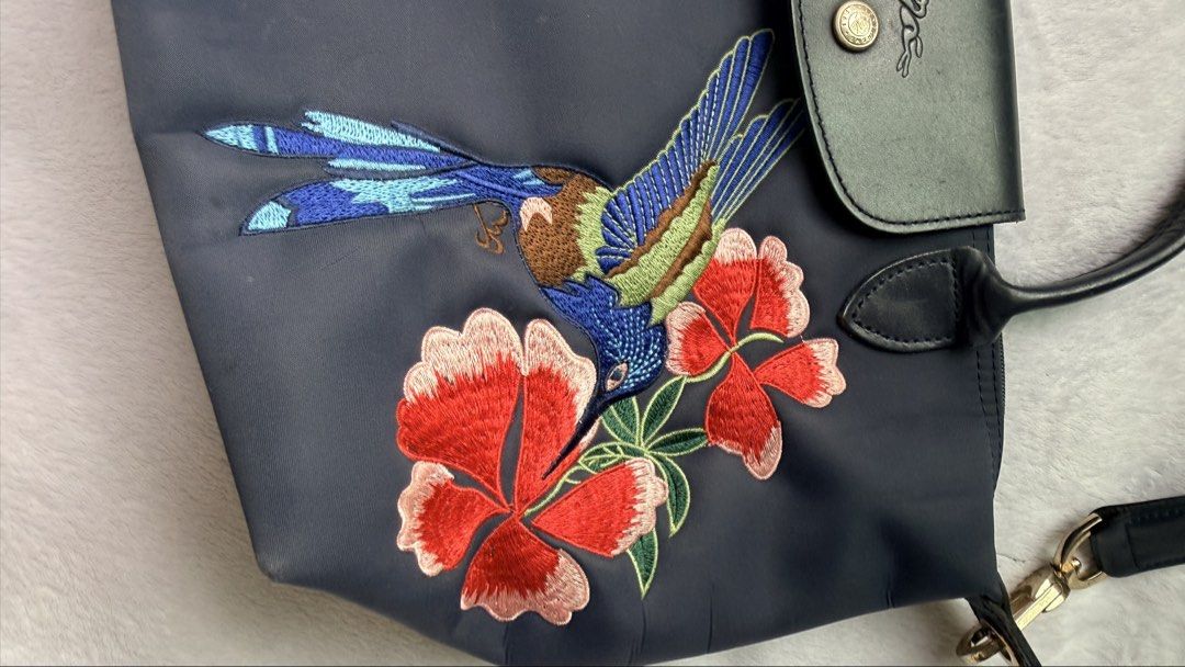 Longchamp Le Pliage Neo Robin bag (Category: Luxury Bags & Wallets) located in Quezon City. Submitted by shane_blueraee (Listing ID 1465392623, Image 3). Description: Authentic Longchamp Le Pliage Neo Robin nylon bag Color: Navy blue Features hummingbird and red floral embroidery on the front - Includes a detachable matching dark blue crossbody strap With light sign of use other than that no other flaw SF c/o buyer - delivery thru lalamove Meet u