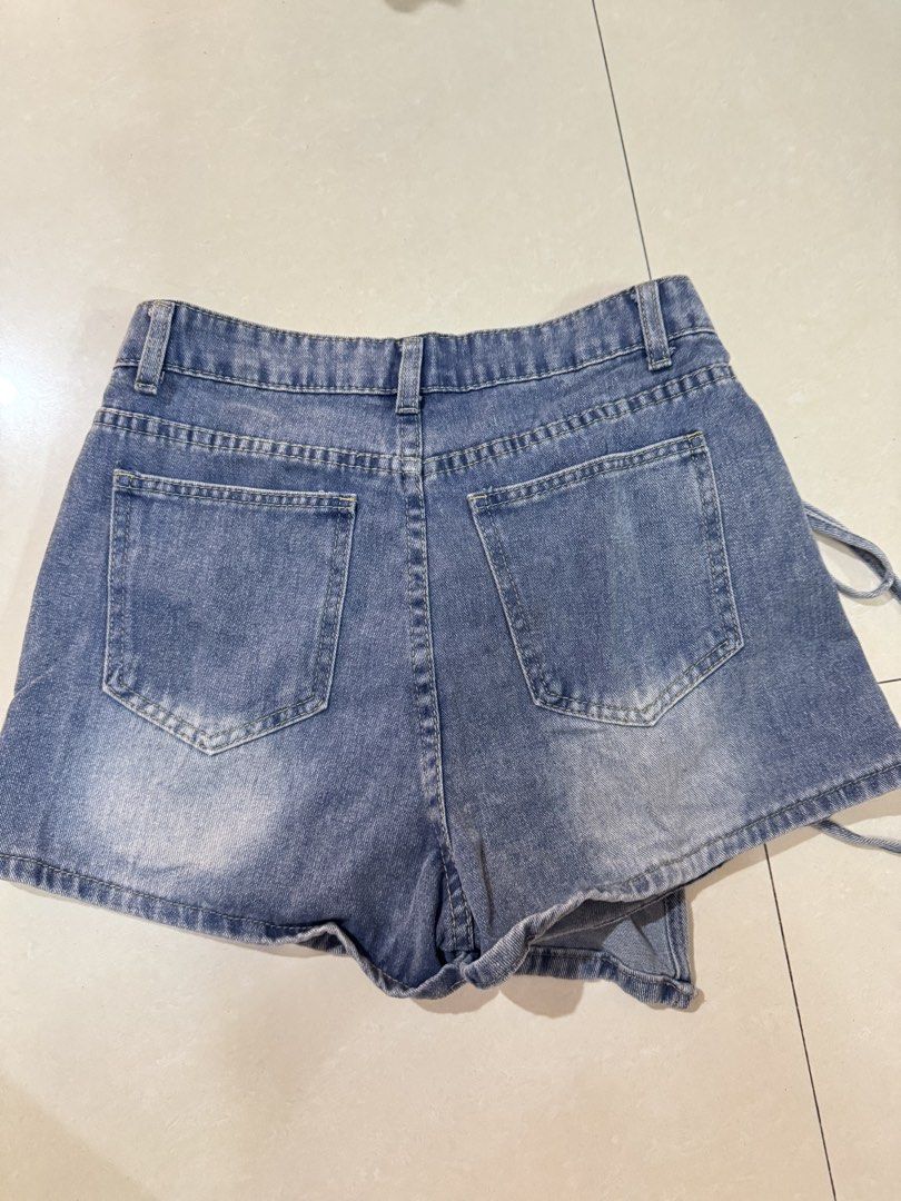 Lovito Blue Denim Skort (Category: Skirts) located in Quezon City. Submitted by sweetlyluxe (Listing ID 1465481561, Image 3). Description: - Brand: Lovito - Item: Denim Skort - Color/Wash: Blue wash - Size: Medium (EU 36, US 6) - Features: Front wrap-style flap with string tie detail, built-in shorts underneath, zipper fly with metal button, and two functional back pockets - Condition: Worn a few times, still in great shape.