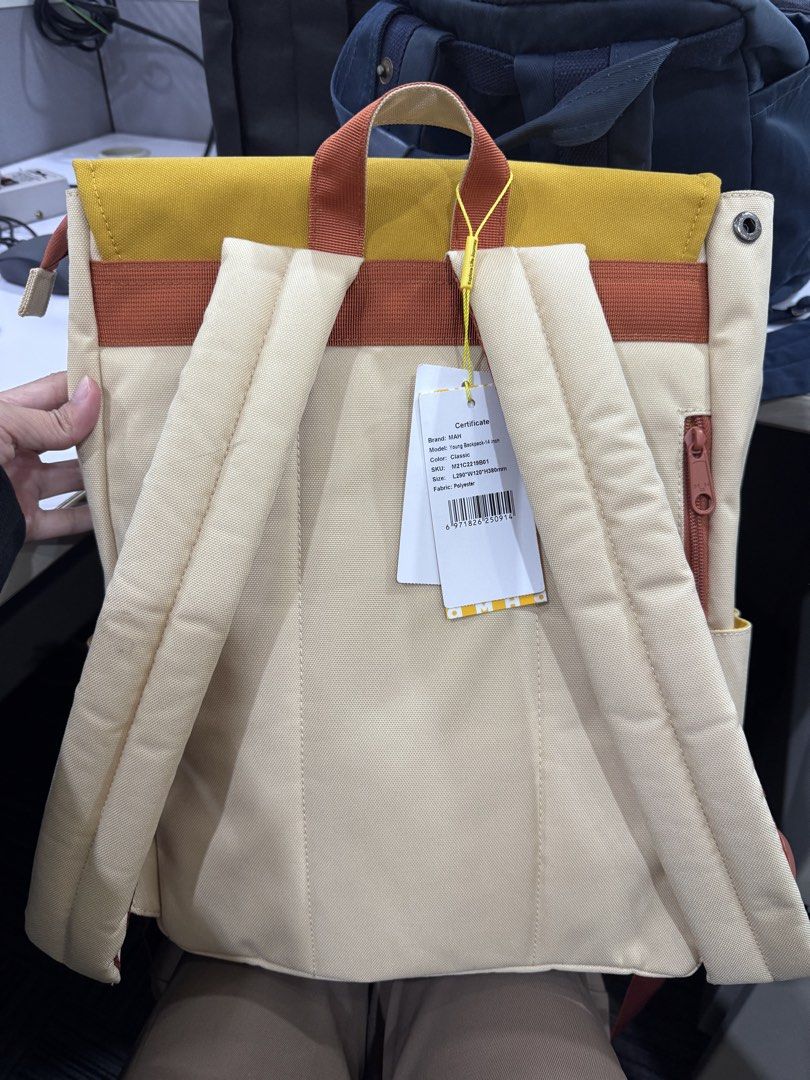 MAH Young Backpack 14-inch Classic (Category: Backpacks) located in Pasig City. Submitted by rowie_08 (Listing ID 1465518946, Image 3). Description: - Brand: MAH (14-inch size) - Colorway: Classic beige, yellow, and rust orange - Material: Durable polyester fabric - Condition: Brand new and unused, complete with original tags and certificate tag on the back strap - Features: Magnetic snap front flap closure, secure zippered back pocket, and a roo