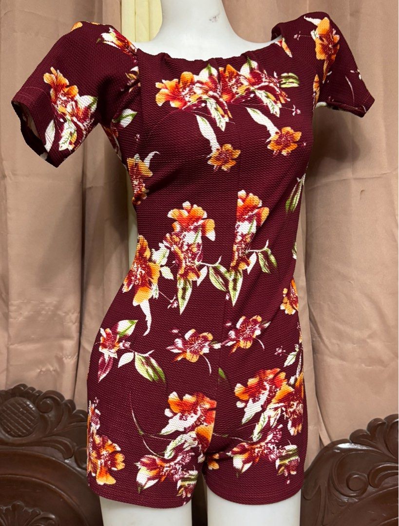 Maroon Floral Short Sleeve Romper (Category: Rompers) located in Marikina City. Submitted by lorradel (Listing ID 1465389072, Image 1). Description: - fits M- L - Color & Print: Maroon with vibrant orange and white floral print - Style: Off-shoulder neckline with short sleeves and form-fitting waist - Material: Lightweight textured bubble fabric for maximum comfort - Fit: Easy slip-on style with short bottoms - Condition: like new / Excellent (re
