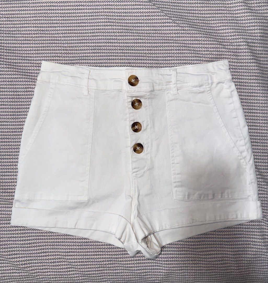 Mi Ami White High-Waisted Shorts Size M (Category: Shorts) located in Santa Ana. Submitted by fatikilla (Listing ID 1465432368, Image 1). Description: - Brand: Mi Ami - Size: Medium - Color: Crisp white denim - Closure: Button-down front with 4 brown buttons - Pockets: Large front patch pockets on both sides - Hem: Cuffed style - Condition/Vibe: Clean look, perfect for warm weather and sunny days.