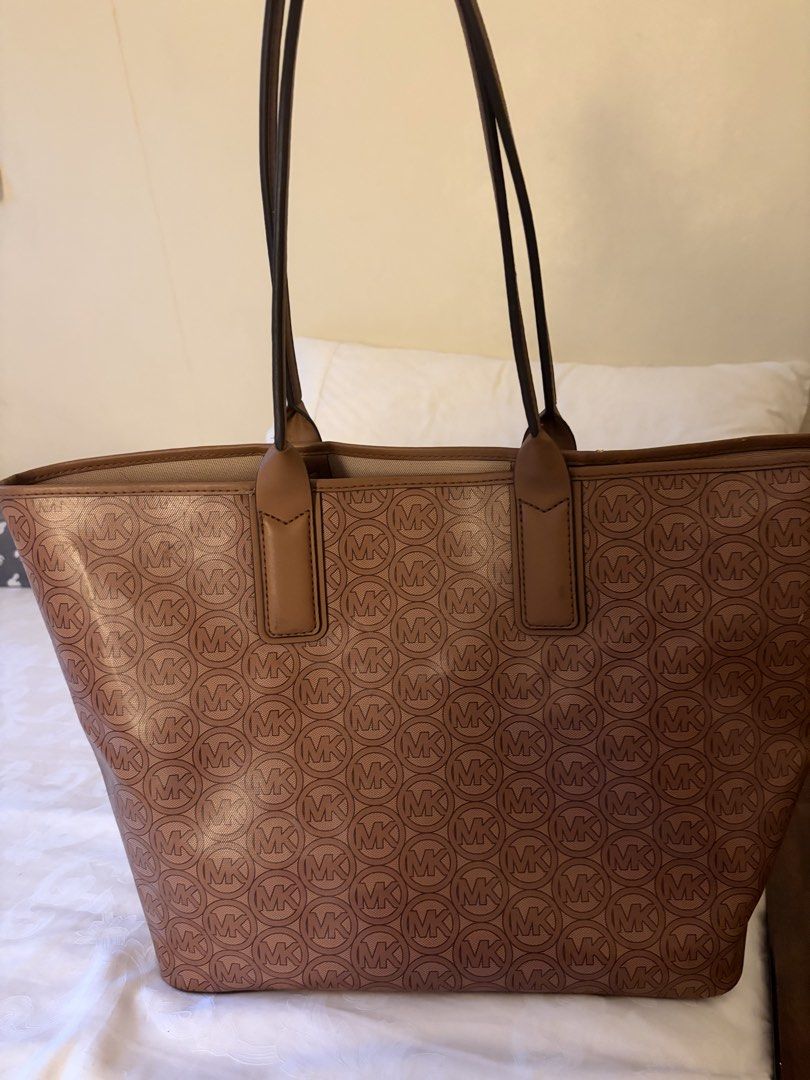 Michael Kors Brown MK Monogram Tote Bag (Category: Luxury Bags & Wallets) located in Cainta. Submitted by kayden1912 (Listing ID 1465456171, Image 2). Description: - Authentic Michael Kors brown monogram tote bag - Structured silhouette with sturdy, comfortable shoulder straps - Elegant gold-tone hardware with front logo lettering - Spacious interior ideal for daily work essentials or running errands - Condition: Excellent / Well-maintained - Mod