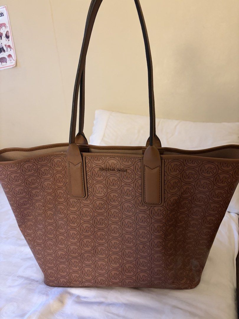 Michael Kors Brown MK Monogram Tote Bag (Category: Luxury Bags & Wallets) located in Cainta. Submitted by kayden1912 (Listing ID 1465456171, Image 1). Description: - Authentic Michael Kors brown monogram tote bag - Structured silhouette with sturdy, comfortable shoulder straps - Elegant gold-tone hardware with front logo lettering - Spacious interior ideal for daily work essentials or running errands - Condition: Excellent / Well-maintained - Mod