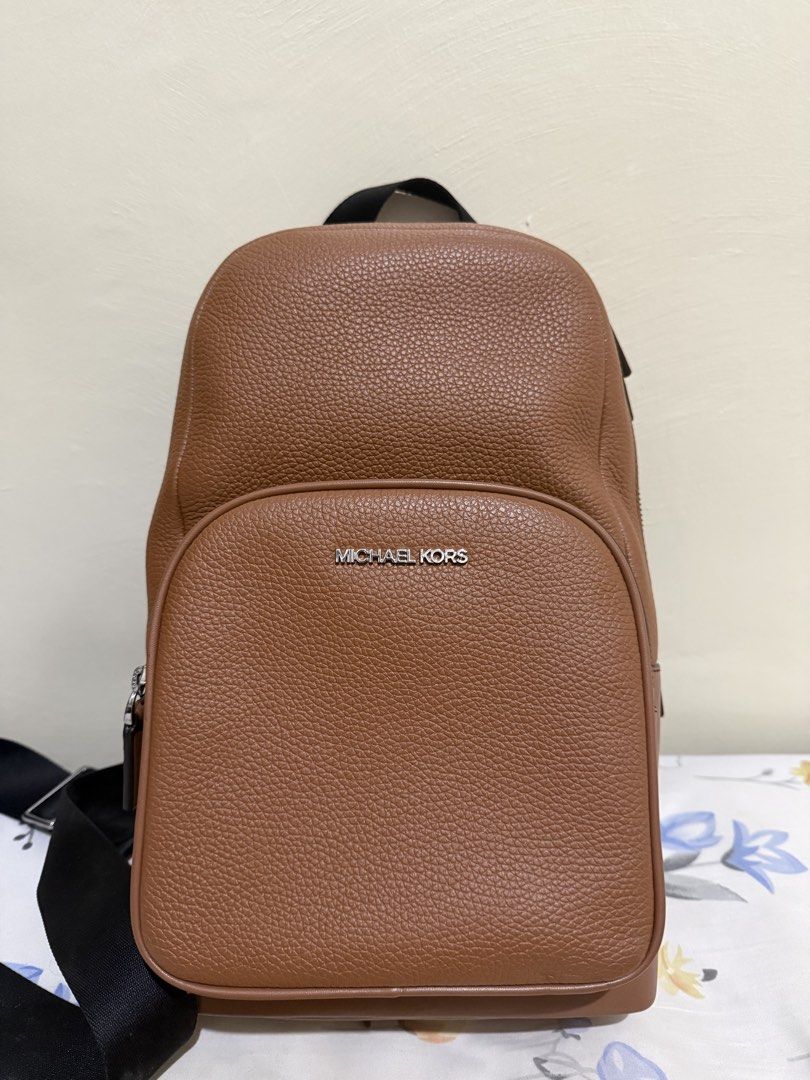 Michael Kors Cooper Pebbled Leather Sling Bag (Category: Backpacks) located in Quezon City. Submitted by zeepeebee (Listing ID 1465507323, Image 1). Description: - Brand: Michael Kors - Material: Textured brown leather with silver hardware - Design: Front pocket with logo lettering, secure zip closures - Comfort: Adjustable black webbing strap & breathable mesh back panel - Interior: Clean lining with handy slip pockets - Condition: Excellent / W