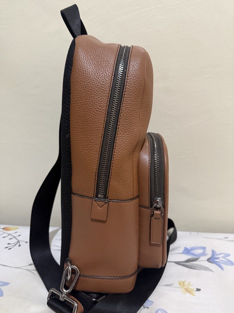 Michael Kors Cooper Pebbled Leather Sling Bag (Category: Backpacks) located in Quezon City. Submitted by zeepeebee (Listing ID 1465507323, Image 3). Description: - Brand: Michael Kors - Material: Textured brown leather with silver hardware - Design: Front pocket with logo lettering, secure zip closures - Comfort: Adjustable black webbing strap & breathable mesh back panel - Interior: Clean lining with handy slip pockets - Condition: Excellent / W