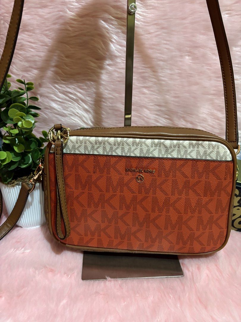 Michael Kors Orange Monogram Crossbody Bag (Category: Luxury Bags & Wallets) located in Tuguegarao City. Submitted by closet_jz (Listing ID 1465393303, Image 3). Description: - Brand: Michael Kors - Design: Vibrant orange monogram print with brown trim and cream top band - Hardware: Gold-tone - Closure: Top zip with MK logo ring zipper pull - Strap: Adjustable brown leather strap - Interior: Clean lining with a structured rectangular shape - Cond