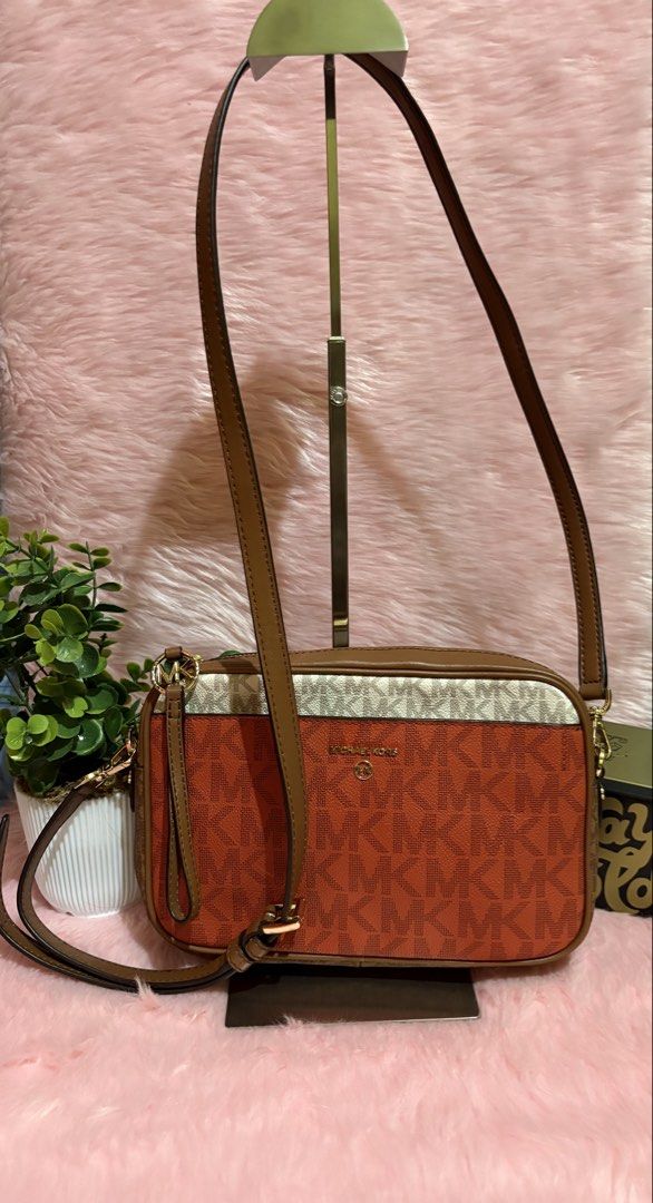Michael Kors Orange Monogram Crossbody Bag (Category: Luxury Bags & Wallets) located in Tuguegarao City. Submitted by closet_jz (Listing ID 1465393303, Image 1). Description: - Brand: Michael Kors - Design: Vibrant orange monogram print with brown trim and cream top band - Hardware: Gold-tone - Closure: Top zip with MK logo ring zipper pull - Strap: Adjustable brown leather strap - Interior: Clean lining with a structured rectangular shape - Cond