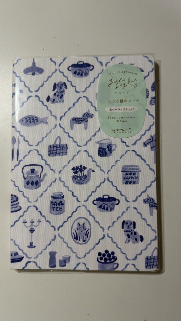Midori Yuru Log Notebook B6 Blue (Category: Stationery & School Supplies) located in Rizal. Submitted by artandjournals (Listing ID 1465567928, Image 1). Description: - Brand: Midori (Designphil) - Style: Yuru Log (Casual life log) - Design: Blue and white pattern with cute illustrations (fish, dogs, teapots) - Size: B6 - Pages: 80 pages with 5mm dot grid - Condition: Brand new in original plastic packaging.