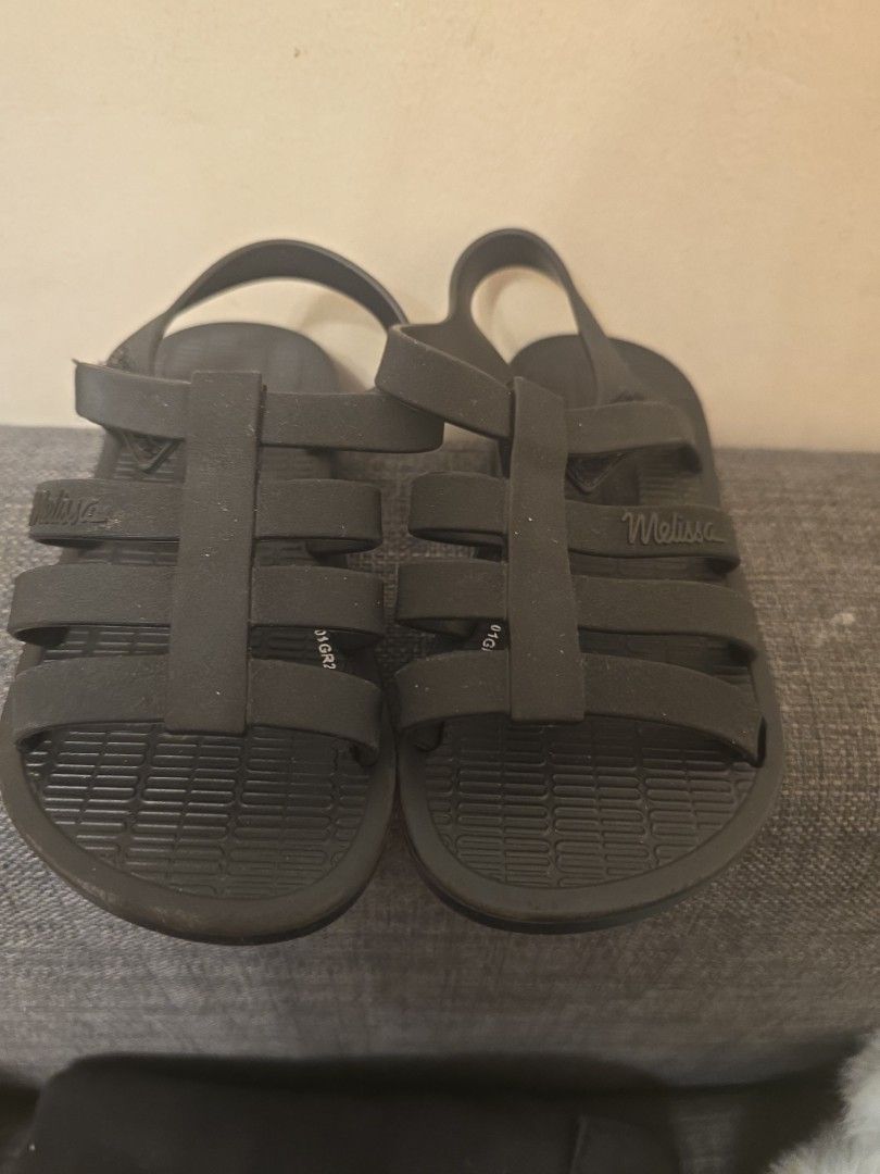 Mini Melissa Strappy Sandals (Category: Babies & Kids Fashion) located in Pasig City. Submitted by balsamo.hrdms (Listing ID 1465406333, Image 2). Description: - Color: Black - Material: Waterproof rubber - Design: Slip-on with multiple top straps and back heel strap - Condition: Clean and well-maintained - Best for: Casual walking, beach trips, and everyday wear.