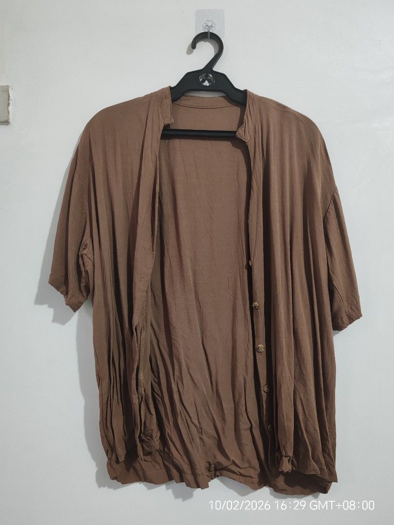 Mocha Oversized Button-Down Top | Loose Fit (Category: Blouses) located in Antipolo. Submitted by purpleclover11 (Listing ID 1465449609, Image 2). Description: Mocha oversized button-down top with a relaxed, flowy fit. Features a simple collarless/V-neck design, short sleeves, and button-down front. Lightweight and easy to pair with jeans, shorts, or trousers. • Brand: Unbranded • Color: Mocha / Brown • Fit: Oversized / Loose fit • Washed once • 