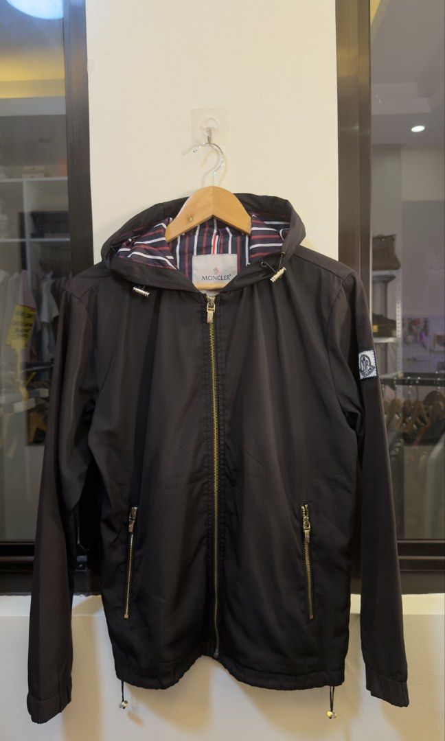 Moncler Hooded Zip Jacket Black Striped Lining (Category: Coats, Jackets and Outerwear) located in Paranaque City. Submitted by preluxeshop_ph (Listing ID 1465549357, Image 2). Description: Moncler Hooded Zip Jacket Black Striped Lining - Color: Black with signature navy, red, and white striped lining - Hardware: Premium gold-tone with functional front zipper pockets - Features: Adjustable drawstring on both the hem and hood - Branding: Classic M