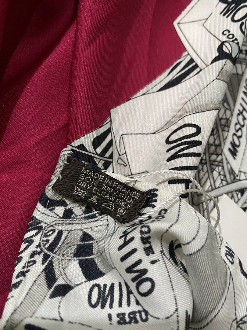 Moschino Couture Silk Scarf (Category: Scarves) located in Pozorrubio. Submitted by izaykite2g (Listing ID 1465524588, Image 3). Description: - Brand: Moschino Couture - 34 x 34.5 inches - Material: 100% Silk (Made in France) - Design: Bold red center with a black and white illustrated shopping bag and box graphic border - Shape: Square - Condition: Brand new with original tags still attached - Perfect luxury gift or stylish accessory.