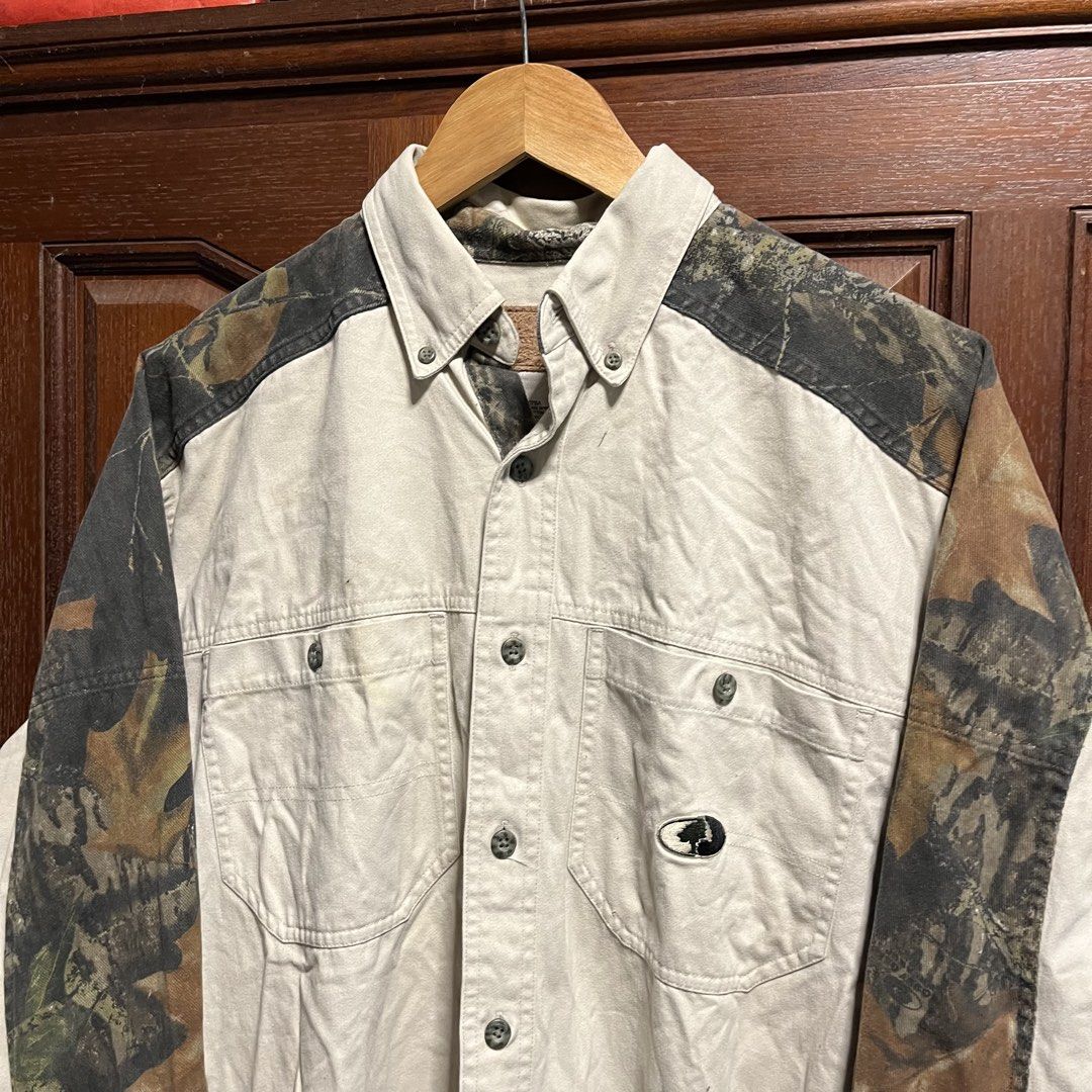 Mossy Oak Open Range Camo Panel Button-Up Shirt (Category: Tshirts & Polo Shirts ) located in Manila. Submitted by thriftyyyyy. (Listing ID 1465533844, Image 2). Description: - Brand: Mossy Oak - Size: Medium (M) - Color: Cream with woodland camo panels - Material: 100% heavyweight cotton (Made in Indonesia) - Features: Dual chest pockets, button-up front, and collar - Style: Utility, outdoor wear, vintage casual.