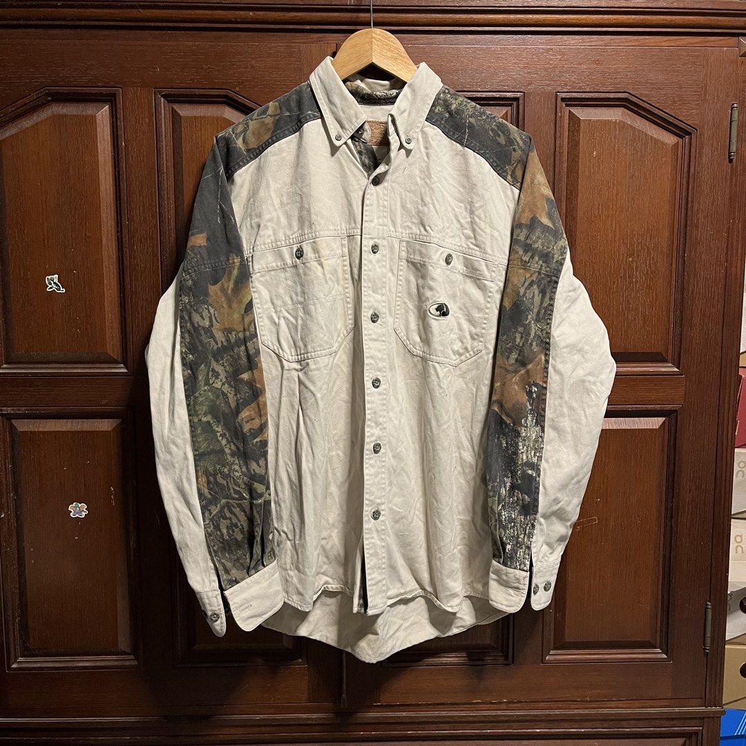 Mossy Oak Open Range Camo Panel Button-Up Shirt (Category: Tshirts & Polo Shirts ) located in Manila. Submitted by thriftyyyyy. (Listing ID 1465533844, Image 1). Description: - Brand: Mossy Oak - Size: Medium (M) - Color: Cream with woodland camo panels - Material: 100% heavyweight cotton (Made in Indonesia) - Features: Dual chest pockets, button-up front, and collar - Style: Utility, outdoor wear, vintage casual.