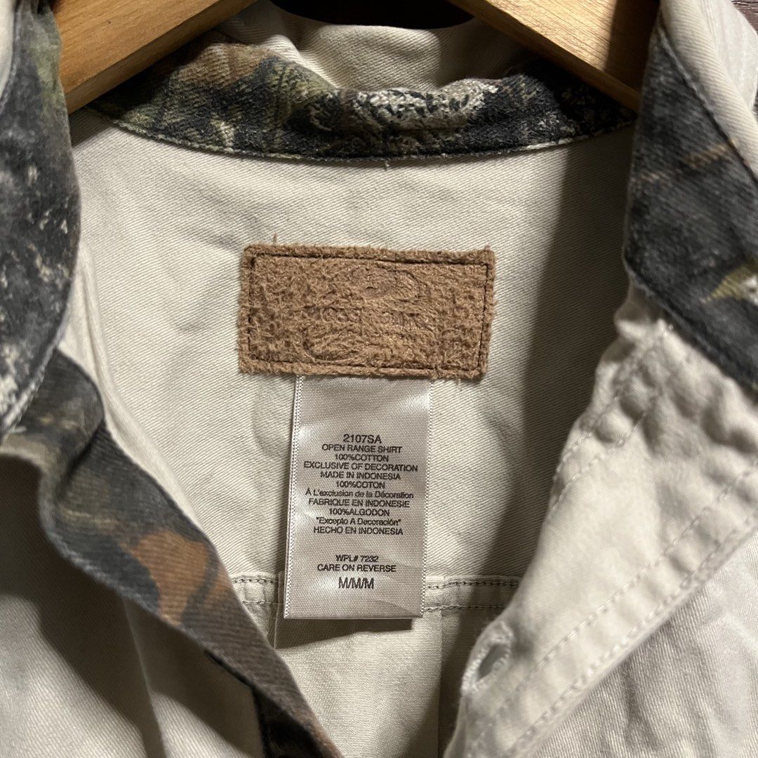 Mossy Oak Open Range Camo Panel Button-Up Shirt (Category: Tshirts & Polo Shirts ) located in Manila. Submitted by thriftyyyyy. (Listing ID 1465533844, Image 3). Description: - Brand: Mossy Oak - Size: Medium (M) - Color: Cream with woodland camo panels - Material: 100% heavyweight cotton (Made in Indonesia) - Features: Dual chest pockets, button-up front, and collar - Style: Utility, outdoor wear, vintage casual.
