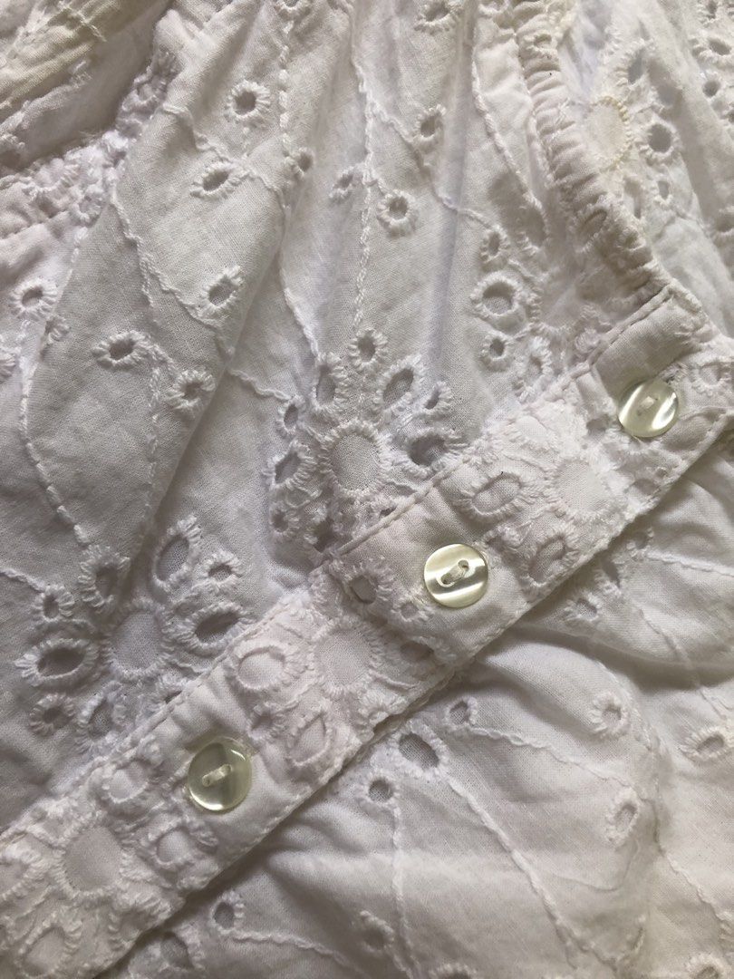Nasty Gal White Eyelet Crop Top (Category: Sleeveless) located in Antipolo. Submitted by jazzminex (Listing ID 1465534692, Image 3). Description: - Brand: Nasty Gal - Style: Cottagecore white eyelet crop top - Details: Square neckline, front buttons, side tie details, low open back - Straps: Ruffled trim - Fabric: Lightweight and breathable - Condition: Excellent.