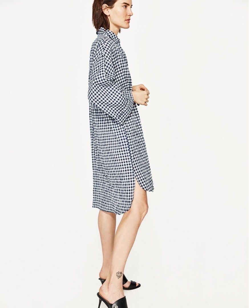 Navy and White Gingham Drawstring Shirt Dress (Category: Dresses) located in Makati City. Submitted by 1st_Dibs (Listing ID 1465417777, Image 2). Description: - Classic navy and white check pattern - Button-up front with a traditional collar and rolled sleeves - Adjustable dark navy drawstring waist for a customized fit - Lightweight, flowy fabric ideal for warm weather - Knee-length with a stylish high-low curved hem - Perfect for easy, casual e