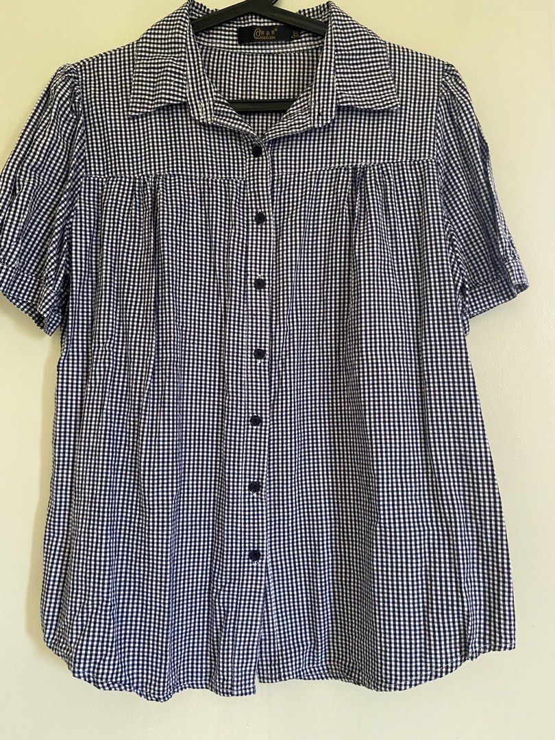 Navy Blue Gingham Short Sleeve Button-Up Blouse (Category: Blouses) located in Quezon City. Submitted by abssnf (Listing ID 1465396236, Image 1). Description: - Navy blue and white gingham check pattern - Short sleeves with cute gathered shoulder detail - Classic collar and front button closure with dark buttons - Lightweight, breathable material for all-day comfort - Relaxed fit, easy to pair with jeans or skirts - Great casual piece for everyda