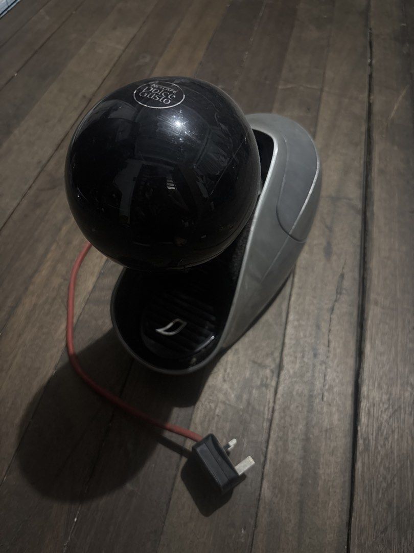 Nescafe Dolce Gusto Coffee Machine (Category: Coffee Machines & Makers) located in Taguig. Submitted by isabaela (Listing ID 1465506776, Image 1). Description: - Brand: Nescafé Dolce Gusto capsule coffee machine - Color: Stylish black and grey spherical design - Condition: Fully working (powers on and heats up normally), with minor surface scuffs from regular kitchen use - Features: Removable clear water tank (clean inside), compatible with all D