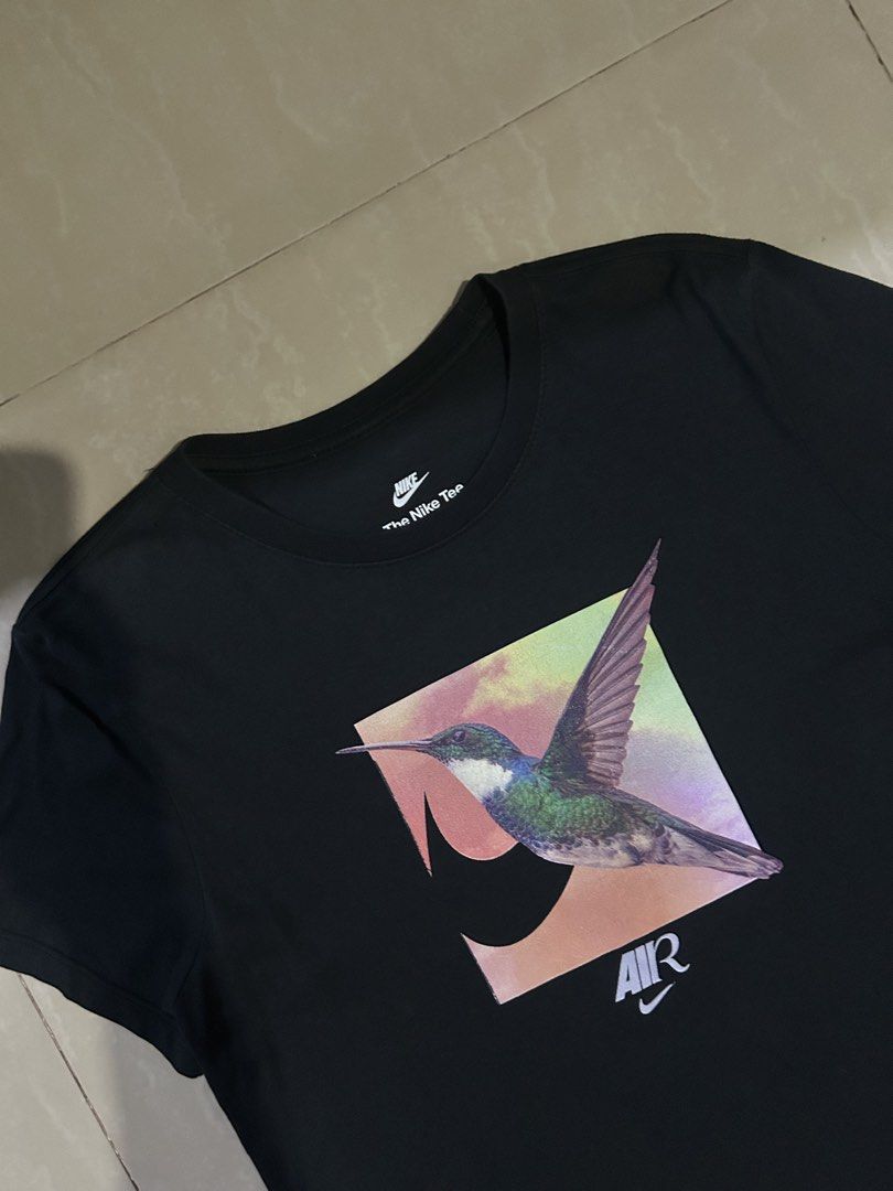 Nike Air Hummingbird Graphic Black Tee Size L (Category: Shirts) located in San Fernando. Submitted by thrift_lang_ni_kim (Listing ID 1465404721, Image 2). Description: 📏 Width: 18.5” 📏 Length: 24” 👕 Best Fit: S 🎨 Color Rate: 9/10 ✅ Condition: Excellent - Brand: Nike (The Nike Tee line) - Style: Black short sleeve crew neck t-shirt with front hummingbird graphic - Size: Large - Condition: Excellent, clean and vibrant print with no cracking or