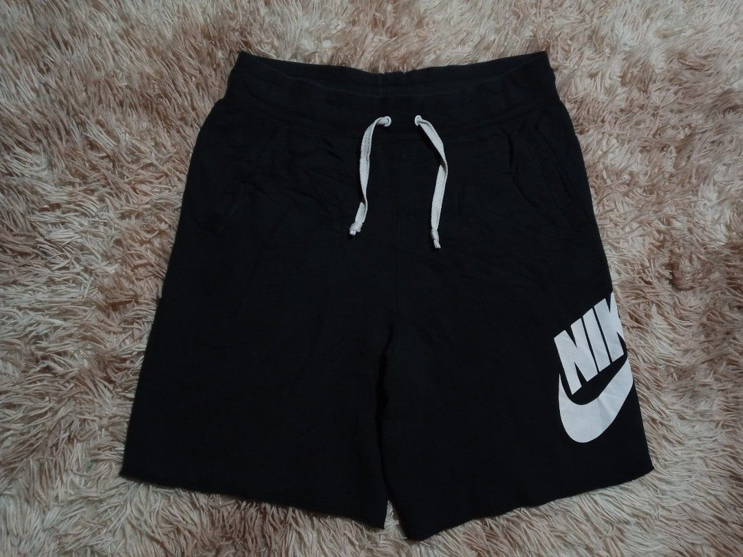 Nike Black Cotton Blend Shorts Size M (Category: Shorts) located in Boston. Submitted by johnpaulvi30029 (Listing ID 1465482919, Image 2). Description: - Brand: Nike - Item: Men's Shorts - Color: Black with white drawstrings and logo - Size: Medium - Design: Large vertical white Nike logo on left leg - Features: Two functional side pockets, adjustable drawstring waistband - Material: 53% cotton, 25% rayon, 17% polyester - Origin: Made in Thailand