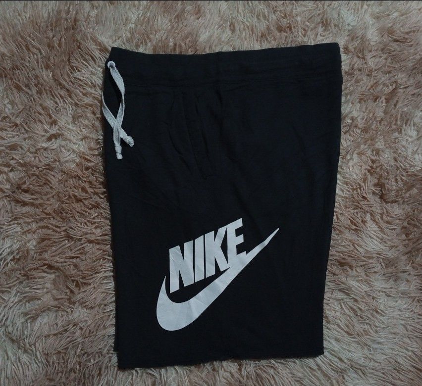Nike Black Cotton Blend Shorts Size M (Category: Shorts) located in Boston. Submitted by johnpaulvi30029 (Listing ID 1465482919, Image 1). Description: - Brand: Nike - Item: Men's Shorts - Color: Black with white drawstrings and logo - Size: Medium - Design: Large vertical white Nike logo on left leg - Features: Two functional side pockets, adjustable drawstring waistband - Material: 53% cotton, 25% rayon, 17% polyester - Origin: Made in Thailand