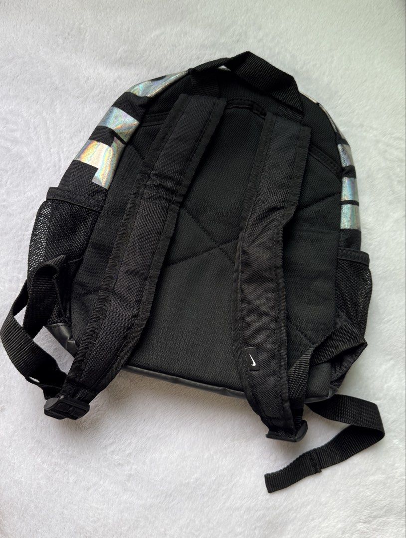 Nike Holographic Mini Backpack (Category: Backpacks) located in Quezon City. Submitted by shane_blueraee (Listing ID 1465402167, Image 2). Description: Nike mini backpack Color: Black with holographic top handle Pockets: Front zipped pocket with 'Just Do It' zipper tag, dual mesh side pockets Straps: Adjustable black shoulder straps - Condition: Pre-loved, faded holographic design (see pic) SF c/o buyer - delivery thru lalamove Meet up - SM North