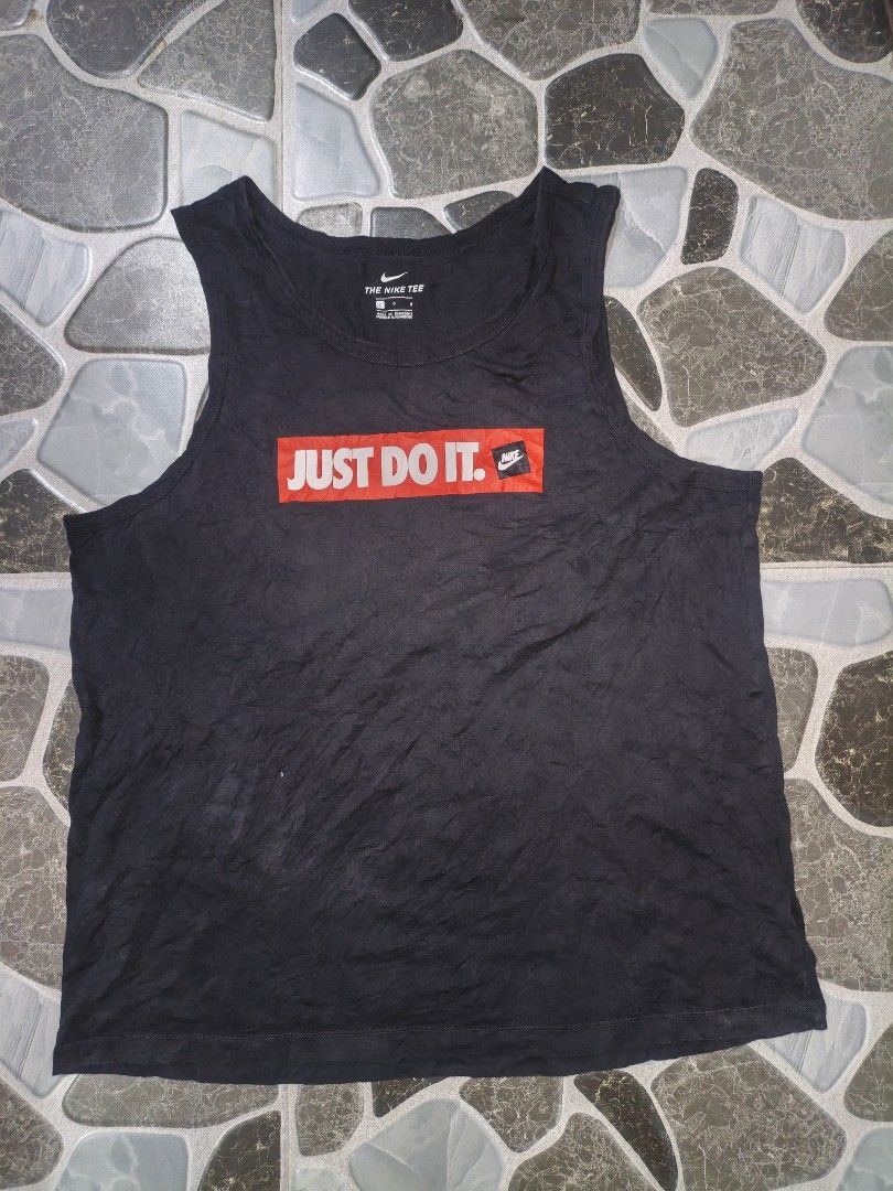 Nike Just Do It Black Tank Top Size L (Category: Activewear) located in Narvacan. Submitted by picky_looter (Listing ID 1465524961, Image 1). Description: Black Nike tank top with large red box graphic on the front reading Just Do It and small Nike logo patch. Size L printed on the inner neck tag and fabric label. Made in Cambodia from cotton material. Standard sleeveless athletic cut with a scoop neckline. Simple everyday sportswear piece..