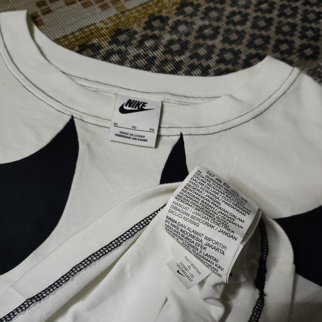 Nike Oversized Swoosh Crop Top (Category: Shirts) located in Taguig. Submitted by althriftdailyloots94 (Listing ID 1465471203, Image 3). Description: - Brand: Nike - Style: Cropped tee with oversized wrap-around black swoosh logos - Fit: Relaxed, boxy fit - Details: Crew neck, short sleeves, and contrast stitching along hems - Size: XL - Material: Cotton (Made in China) - Condition: Clean and ready to wear authentic/Legit need wash only.