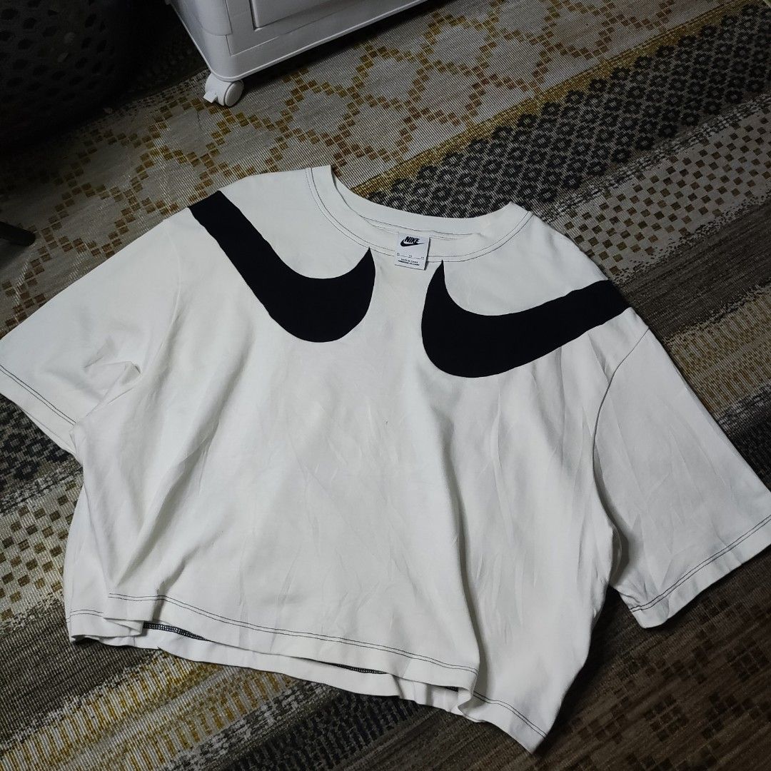 Nike Oversized Swoosh Crop Top (Category: Shirts) located in Taguig. Submitted by althriftdailyloots94 (Listing ID 1465471203, Image 2). Description: - Brand: Nike - Style: Cropped tee with oversized wrap-around black swoosh logos - Fit: Relaxed, boxy fit - Details: Crew neck, short sleeves, and contrast stitching along hems - Size: XL - Material: Cotton (Made in China) - Condition: Clean and ready to wear authentic/Legit need wash only.