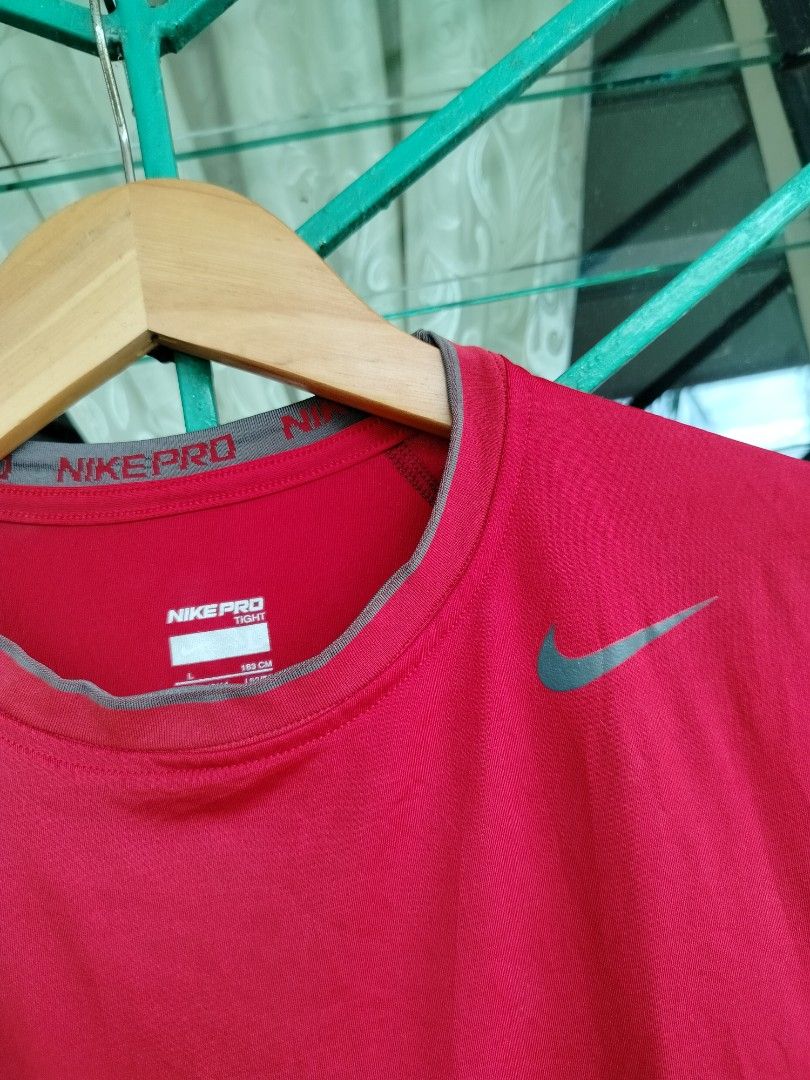 Nike Pro Tight Sleeveless Red Tank Top (Category: Activewear) located in Manila. Submitted by gerald_quinto (Listing ID 1465472952, Image 2). Description: - Brand: Nike Pro - Color: Bright red with gray collar trim - Size: Large (L) - Fit: Tight, athletic fit - Material: Lightweight and breathable - Condition: Authentic with clear tag details visible.