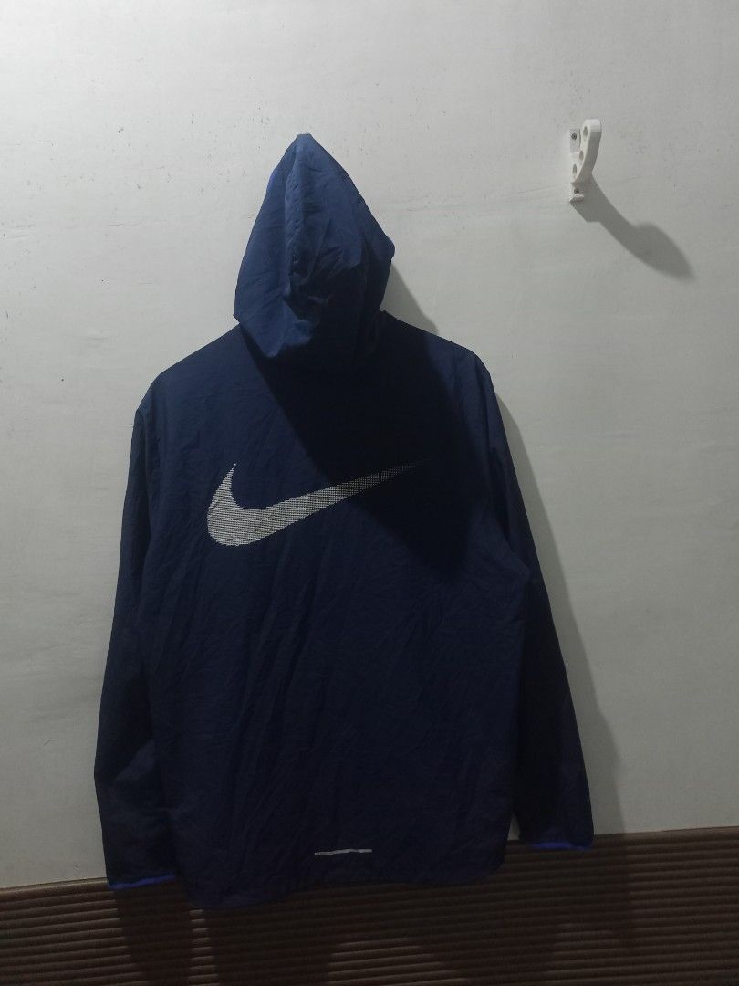 Nike Running Hooded Jacket Blue Size L (Category: Coats, Jackets and Outerwear) located in Taguig. Submitted by mvdsh0p2022 (Listing ID 1465511845, Image 3). Description: - Brand: Nike - Item: Running Jacket - Color: Dark blue with bright blue accents - Size: L (Tag on inner collar and wash label) - Features: Hooded, full-zip design, Nike Running text on left sleeve, large Nike logo graphic on the back - Material: 100% polyester Nike Running Jack