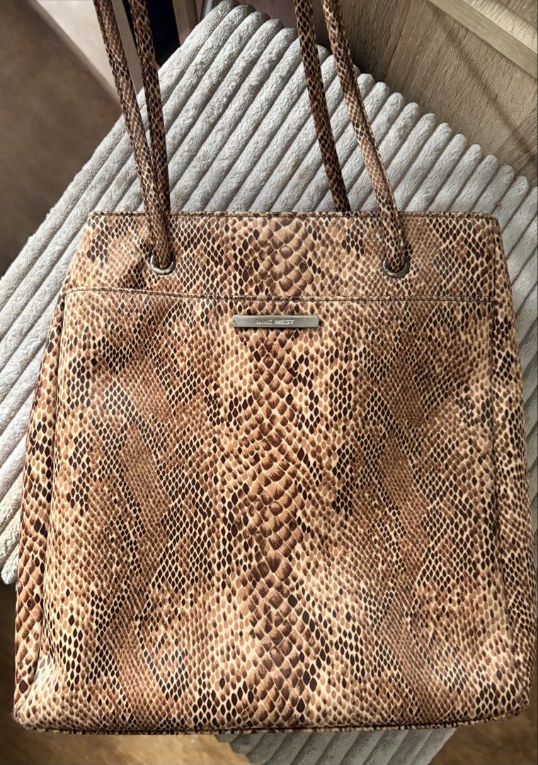 Nine West Tote Shoulder Bag (Category: Tote Bags) located in Quezon City. Submitted by rushcanon (Listing ID 1465404505, Image 1). Description: - Brand: Nine West - Condition: Clean inside and out with minimal signs of wear, perfect for everyday use 7.5/10 -Size: fits an iPad (10.2) - Material/Design: Chic brown snakeskin print with structured shape - Hardware: Silver-tone rings and metal brand plate - Straps: Double shoulder straps - Compartment