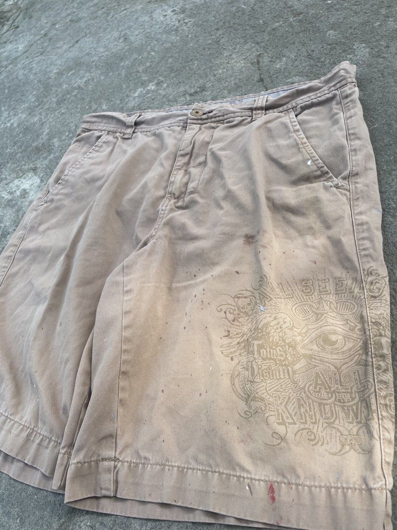 No Boundaries Khaki Shorts with Graphic Print (Category: Shorts) located in Manila. Submitted by chocoballsss (Listing ID 1465464671, Image 2). Description: - Brand: No Boundaries - Size: Regular fit - Color: Tan khaki - Details: Eye graphic print on lower left leg, front pockets, belt loops, button closure - Material: Lightweight cotton - Condition: Shows minor paint splatters and staining from use.