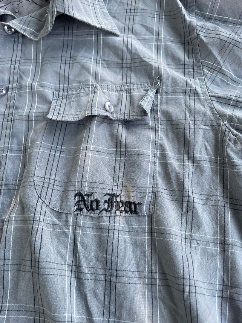 No Fear Grey Plaid Button-Down Shirt Size L (Category: Tshirts & Polo Shirts ) located in Puerto Princesa. Submitted by bestthrift123 (Listing ID 1465404940, Image 2). Description: - Brand: No Fear - Size: L - Color: Grey and black plaid - Style: Button-down shirt with classic collar - Features: Double chest pockets with button flaps and embroidered logo - Vibe: Edgy vintage skater look, great for casual daily wear.