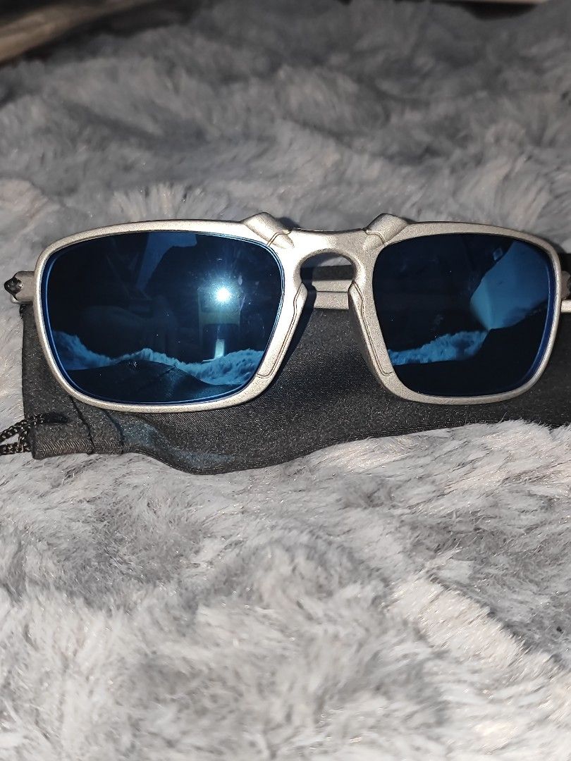 Oakley Square Wire Sunglasses (Category: Sunglasses & Eyewear) located in Manila. Submitted by crazylocc887246 (Listing ID 1465487556, Image 2). Description: - Brand: Oakley - Model: Square Wire - Frame: Textured silver with lightweight arms and blue icon logos on temples - Lenses: Deep blue polarized with bright flash reflection - Inclusions: Soft microfiber pouch - Condition: Excellent / Ready to use.